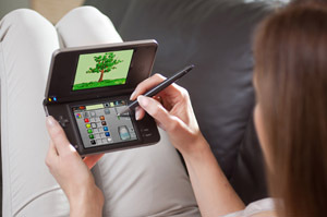 Woman playing Nintendo DSi XL