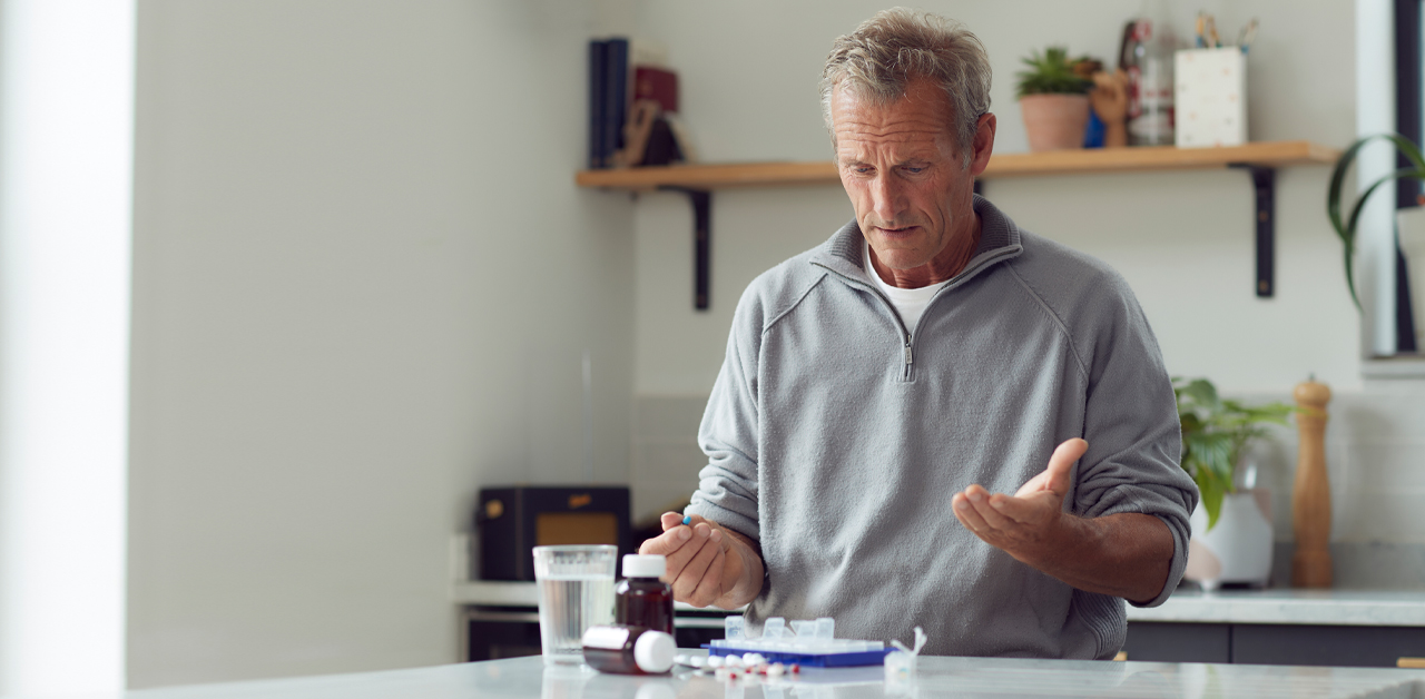 An elderly man opens his PillTime medication package