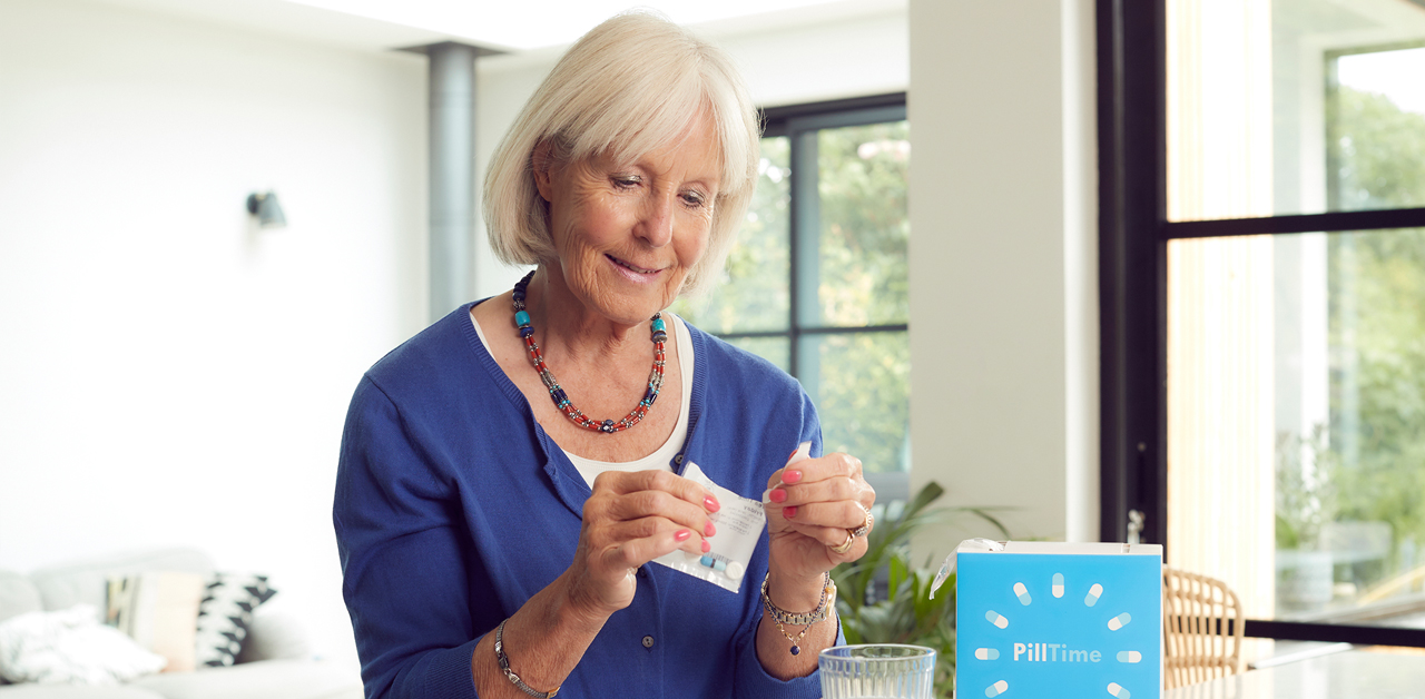 An elderly woman opens her PillTime package