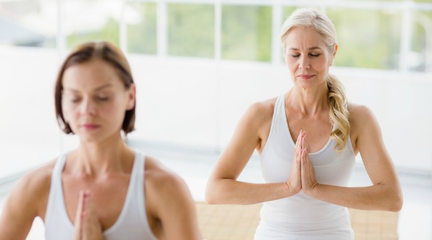 two mature women doing yoga